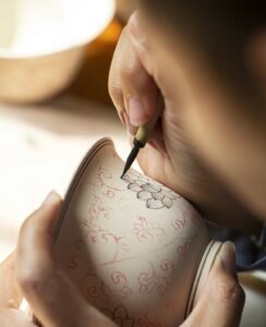 Hand-drawn ceramic pattern close-up: handmade porcelain art vs mass-produced industrial ceramics