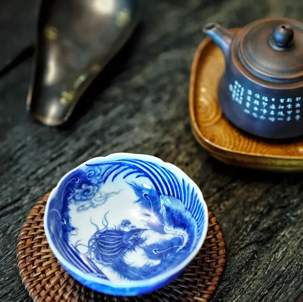 Close-up of hand-painted phoenix pattern on porcelain, highlighting intricate brushwork and artisanal detail