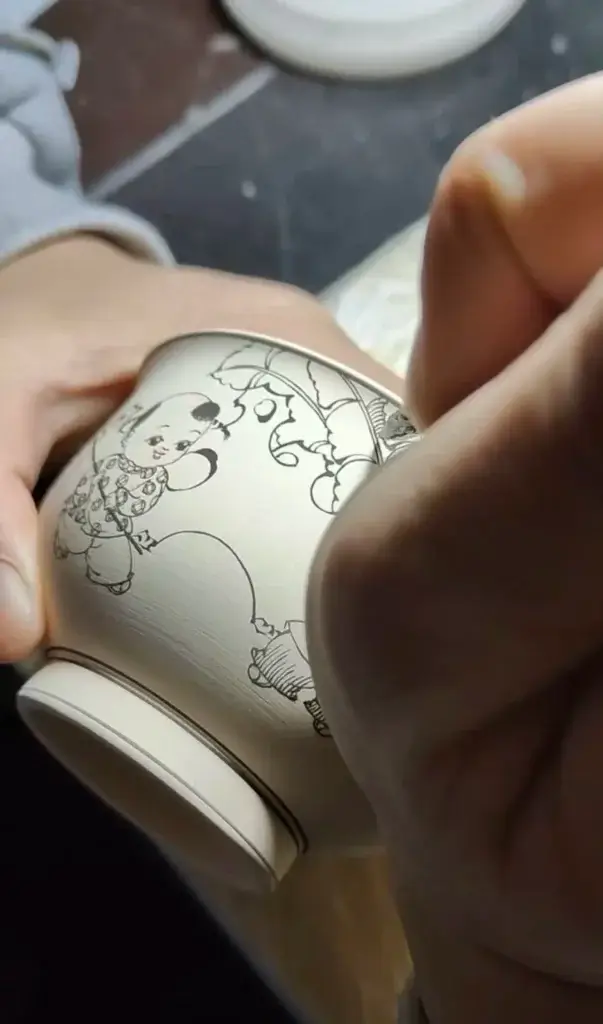 Artisan hand-painting a porcelain cup